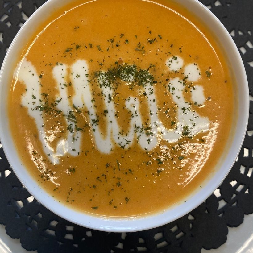 A bowl of squash soup finished with a swirl of cream